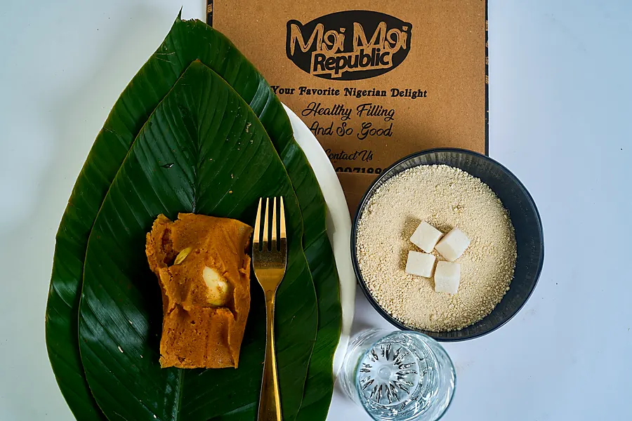 Moi moi on a leaf with garri, sugar and milk